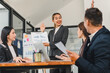 © PRIME STOCK LAB - businesswoman presents marketing report to colleagues in modern office. team engages in discussion, showcasing collaboration and professionalism