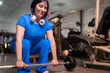 © Guillermo Spelucin - Determined sportswoman lifting weights in modern gym setting