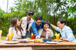 © CandyRetriever  - Group of Happy Asian millennial generation people friends enjoy and fun celebration reunion meeting outdoor dinner party with food and drink together in the garden at restaurant on holiday vacation.