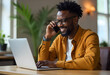 © StockLab - Young African American man in business casual outfit working in bright and airy office next to the windows at his white desk