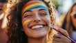 © santi - A smiling person painting a rainbow on their friendâ€™s face during a pride event.