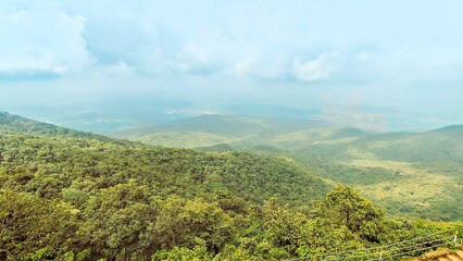 Wall Mural - Scenic view of green mountains under a cloudy sky