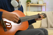 © Prathankarnpap - Cropped shot of guitarist tuning and practicing acoustic guitar at home