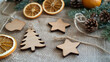 © PickaPic - Wooden ornament cutouts trees, stars, hearts on a burlap background, with some twine and dried orange slices for a rustic touch