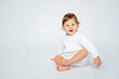 © Any Grant - A baby boy on a white isolated background with a place for text is sitting in white knitted clothes. A small happy child in a winter sweater , space for text