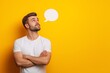 © Andrii Zastrozhnov - A man with a beard and a white shirt is looking at a yellow wall with a speech bubble on it