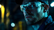 © Alona - A focused industrial worker wearing safety glasses and a cap in a low-light setting.