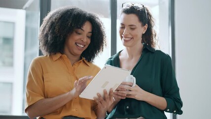 Wall Mural - Video of two smart pretty business women taking a break while cheaking her digital tablet standing in the office