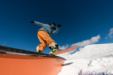 Expert snowboarder balancing and executing tricks on the wallride.