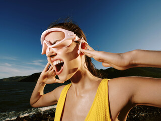 Poster - Snorkeling woman with mask in front of clear blue water, with ocean waves gently rolling in the background under a sunny sky