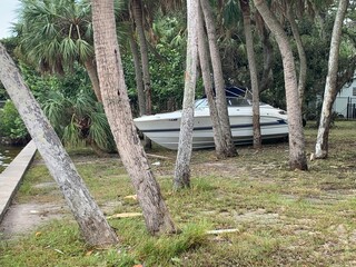 boat washed ashore between trees during hurricane storm surge