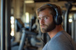 © Michael - Portrait of a focused sportsman wearing headphones and listening to music while taking a break from his workout at the gym