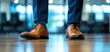 © Ai Stock Lab - Elegant brown shoes worn by a person in formal attire, inside an office environment.