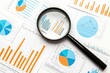 © JK_kyoto - Magnifying glass over detailed graphs and charts depicting statistical data.