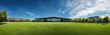 © Yana - Panoramic view of a modern building set against a vibrant blue sky and lush green lawn in a park-like setting