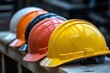 © StockUp - Multiple colored hard hats in a line represent teamwork and preparation in the context of construction safety.