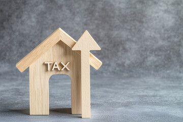 Wooden house with tax symbol and upward arrow representing growth