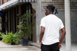 © SOLO PLAYER - Candid of African man model with dreadlocks hairstyle wearing white t-shirt standing in the city