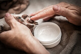 Applying paw ointment or balm on dog paw, protection and caring