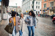 © Davor - Three stylish women walking and laughing together on a city street with coffee