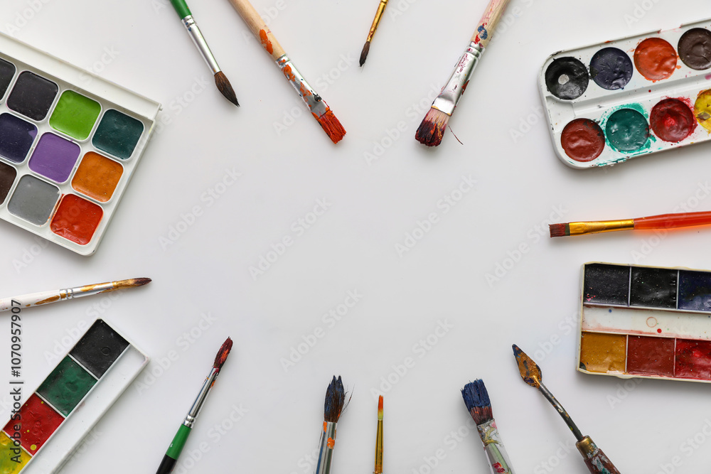 Frame made from artist brushes and paints on white background