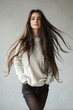 © ArtPixel-Portfolio - Fashion model with long, flowing brunette hair, casually posing in a white sweater and dark pants with hands in pockets