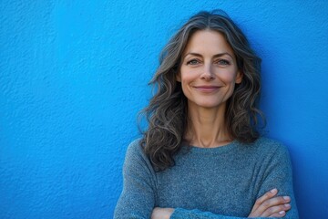 Poster - A woman standing with her arms crossed against a blue background