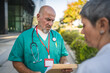 © Miljan Živković - Senior man doctor discuss with female colleague about patients record
