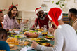 © Wavebreak Media - Celebrating Christmas, diverse multiracial family sharing festive dinner, laughing together at home