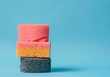 © SHOTPRIME STUDIO - colorful sponges stacked on a light blue background, showcasing vibrant pink, yellow, and gray colors perfect for cleaning or kitchen supplies images