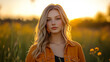 © Jhati - Young woman with long hair stands in a field during sunset, wearing an orange shirt