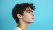 © Nuttaya Nampai - Profile of a Young Man Against a Blue Background