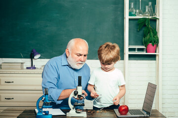 Fototapete - Elementary school and education. Old and Young. Family generation and relations concept. Grandfather with grandson learning together. Educational process.