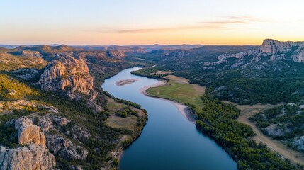 Poster - Scenic aerial view of a winding river through a lush valley at sunset, AI