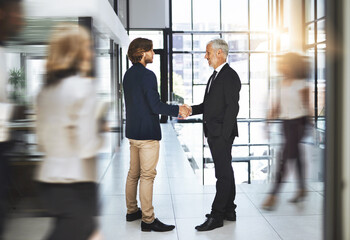 Fototapete - Blur, handshake and meeting with business people in busy workplace for agreement, deal or partnership. Hiring, thank you and welcome with employee men shaking hands in office for B2B collaboration