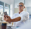 © peopleimages.com - Mature man, phone and vision problem, eyesight and myopia or glaucoma in business office. Mobile, person and poor sight, squinting and manager struggle with reading blurry email online with glasses