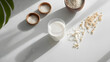 © Anastasia - Clean and fresh photo of rice milk in a glass surrounded by raw rice in bowls and scattered on a surface with natural shadows