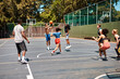© peopleimages.com - People, fitness and playing with ball in basketball court for street sports, game or outdoor match. Young community, group or team players with defense for throw, fun practice or training together