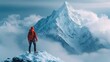 © clarke - At the peak of the majestic mountain peak, a mountain climber stood victoriously
