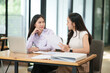 © junjira - Businessman, two Asian women give advice, discuss work, documents on laptop at office