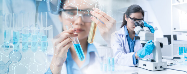 Wall Mural - scientist female researcher with protective glasses examining lab tube with a blue fluid.scientists 