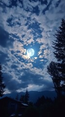 Wall Mural - a large moon is shining brightly in the sky above a small house