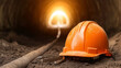 © Nakarin - orange hard hat rests on ground in tunnel, symbolizing safety
