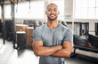 © peopleimages.com - Portrait, fitness and happy man with arms crossed for exercise, body health or wellness in gym. Face, smile or confident African bodybuilder, personal trainer or strong athlete with muscle in Nigeria