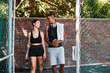 © peopleimages.com - Walking, fitness and talking with interracial couple on court for sports training, health and teamwork. Workout, personal trainer and exercise with man and woman for wellness, summer and performance