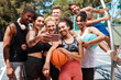 © peopleimages.com - Basketball, group and selfie outdoor on sport court with social media, smile and break. Fitness, team and diversity with workout and training for game with people together and profile picture