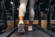 © littlewolf1989 - Close up view of female muscular legs running on the treadmill in the gym.