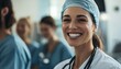 © Adnan - A smiling female doctor wearing a medical cap and stethoscope stands with colleagues in a hospital setting, projecting professionalism and care.