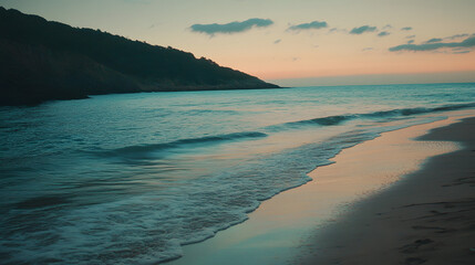 Wall Mural - A quiet beach with soft waves lapping at the shore during sunset.