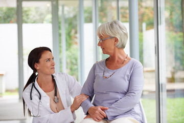 Wall Mural - Elderly woman, doctor and discussion for consultation, medical questions and checkup with patient. Retirement home, mature person and caregiver for health, wellness and healthcare advice in house